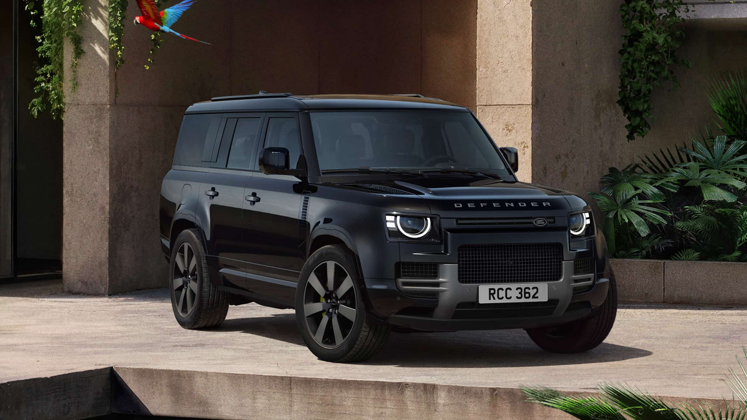 Defender parked in lush greenery and a shaded recessed space