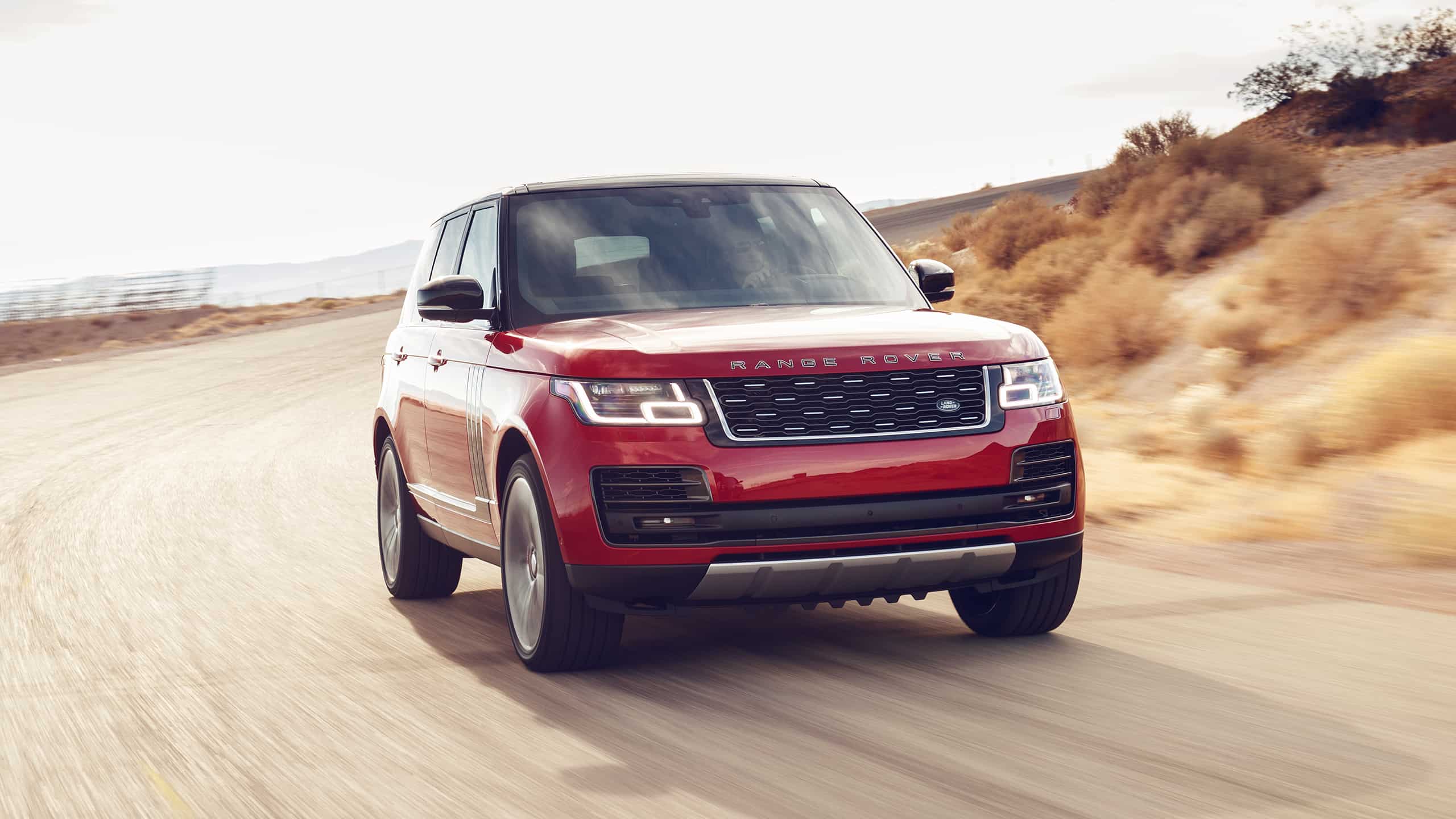 Man is driving Range Rover on the mountain road