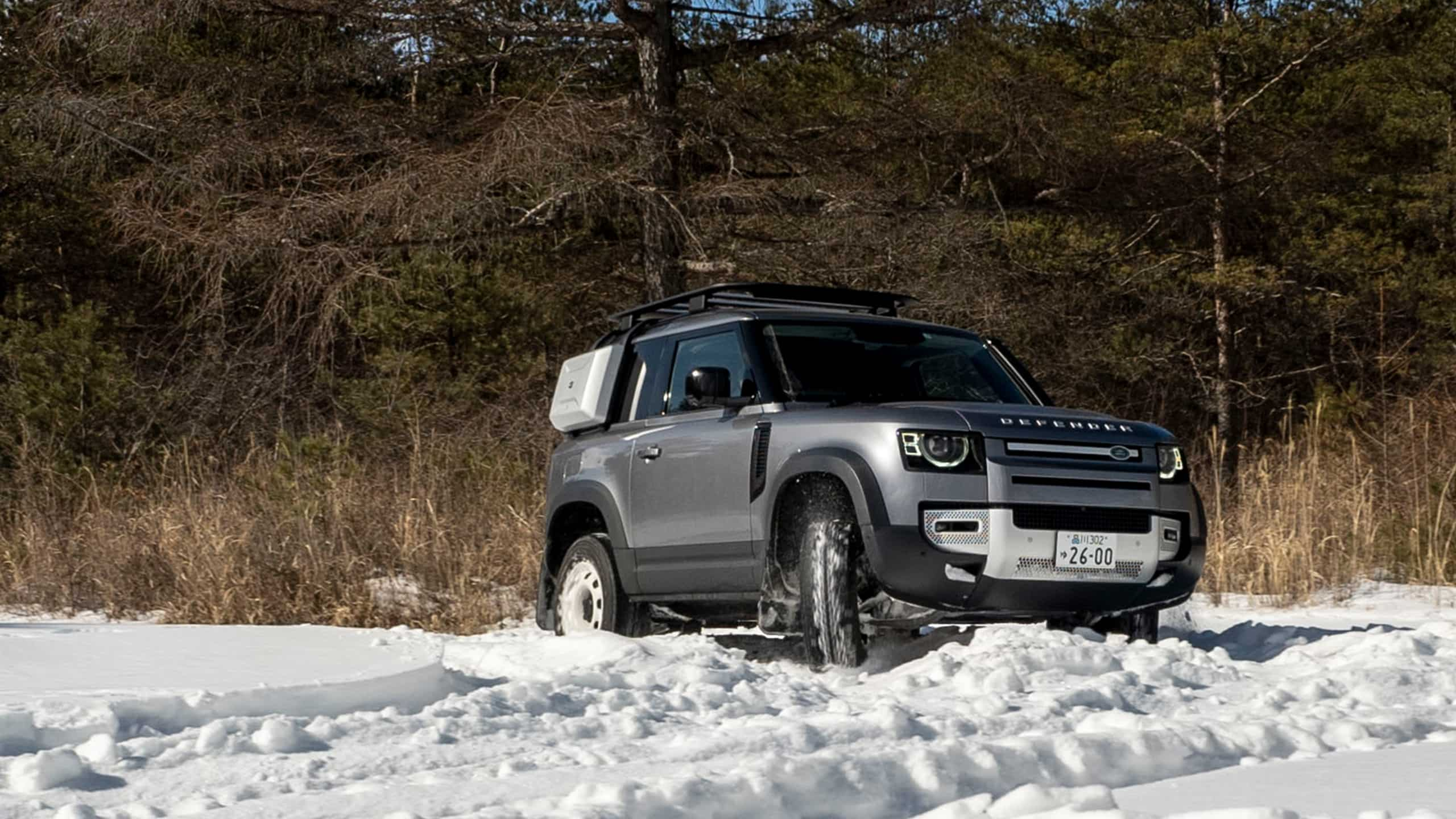 Land Rover Defender crossing on a Snow Forest Road