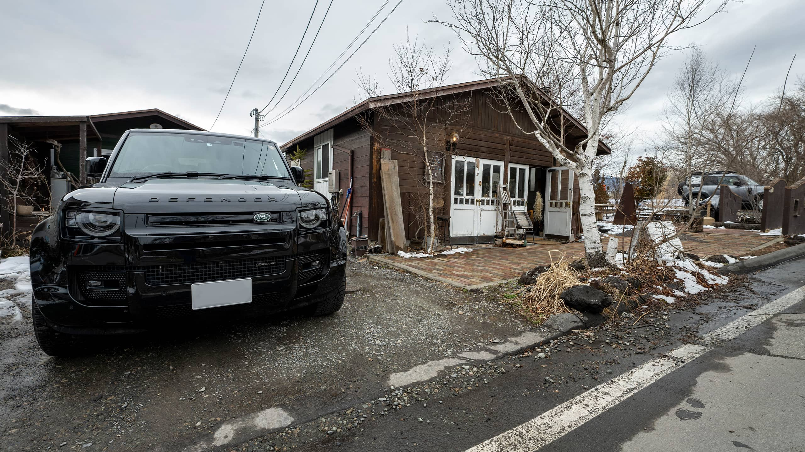 Two Defender Parked outside of the House Road